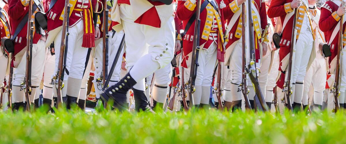 Legs of British soldiers of American revolutionary war on green battlefield in Lexington, MA
