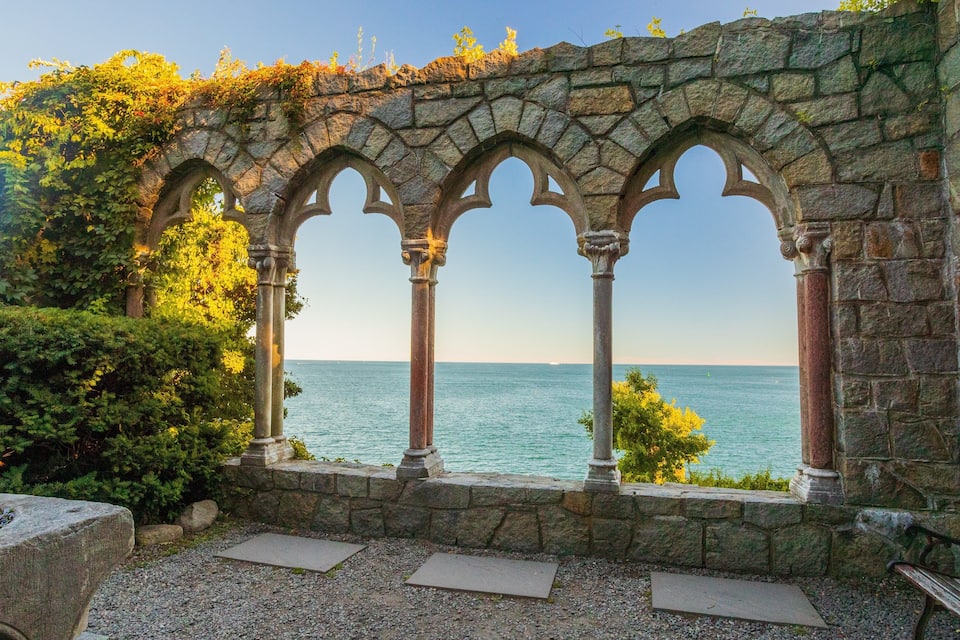 Un arco de piedra con vista al mar.
