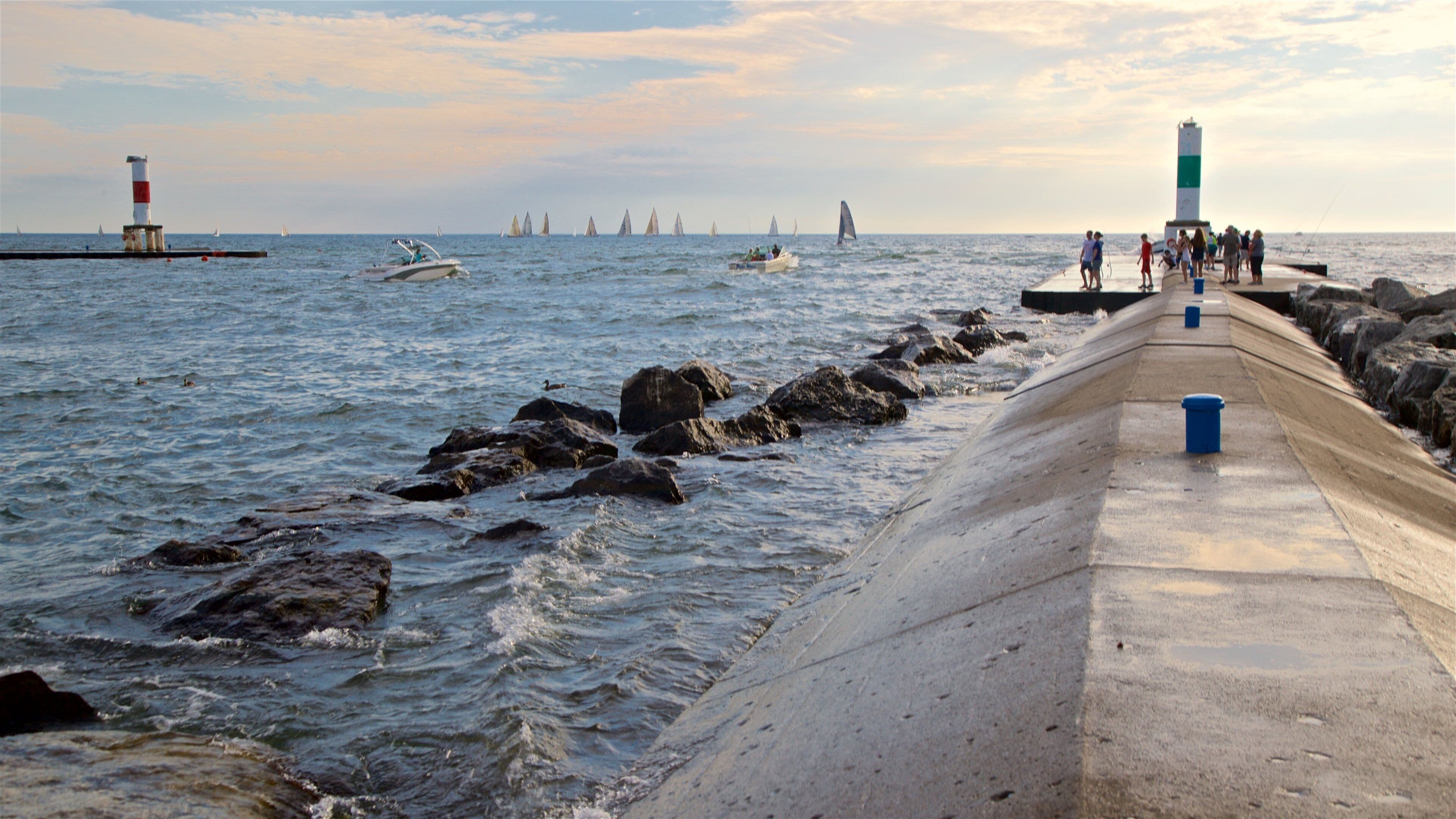 Holland State Park featuring general coastal views and a sunset as well as a small group of people