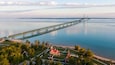 Aerial view of the Mackinac Bridge over calm waters in the morning, with view of the Old Mackinac Lighthouse