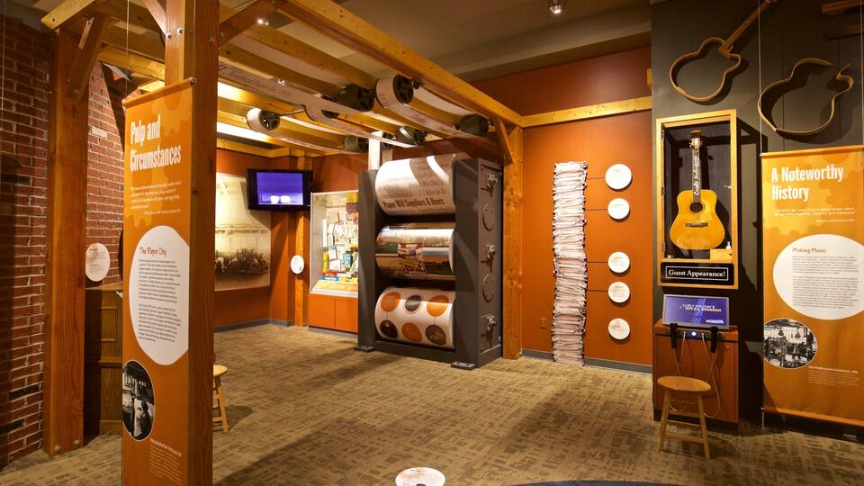 A museum exhibit with historical displays, including a large paper mill machine and guitars.
