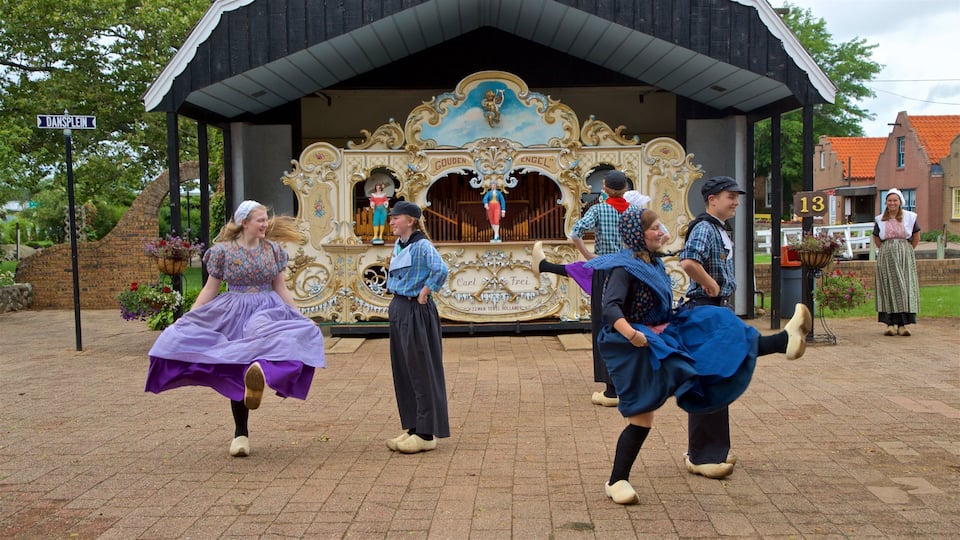 A traditional Dutch dance performance in front of a church with ornate decorations and a sign reading "DANSPEIN".