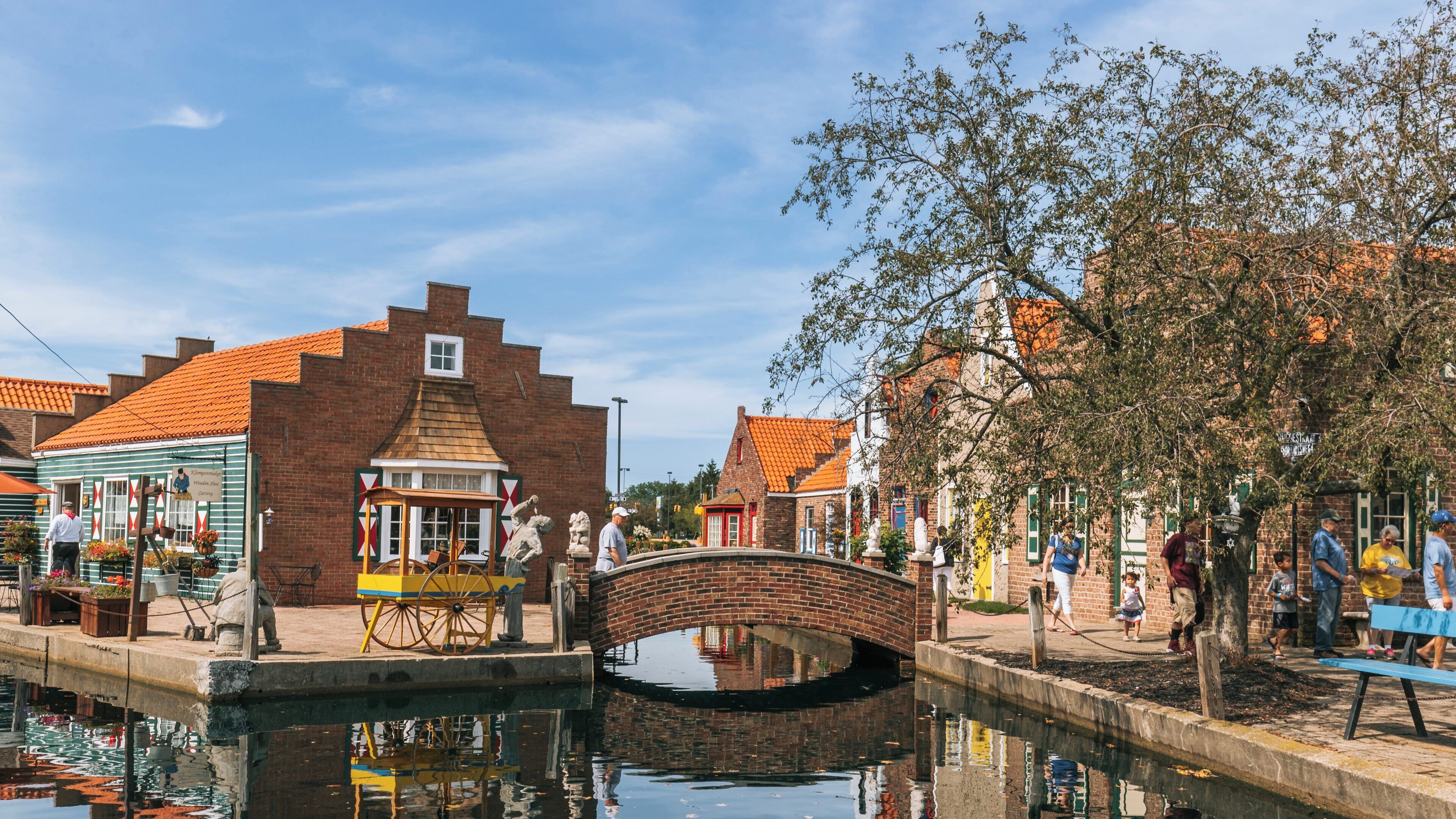 Charming waterfront of Dutch Village in Holland, Michigan showcases colorful buildings and a picturesque bridge