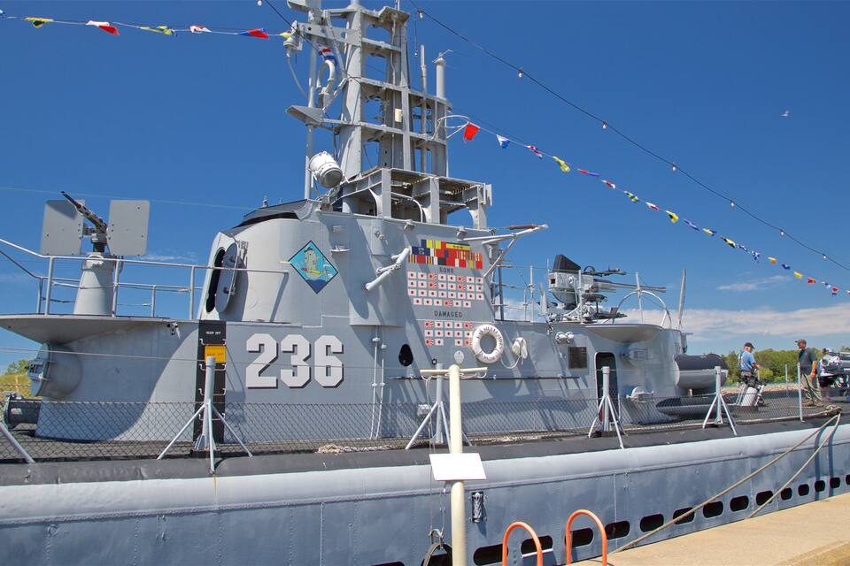 A naval ship with the number 236, flags, and a lifebuoy.