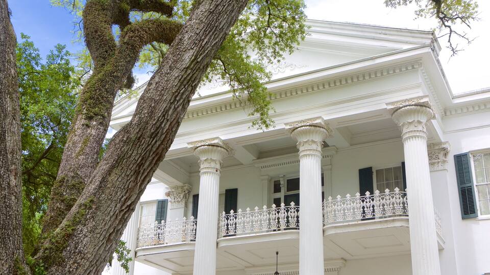 A white colonial-style building with columns and a balcony.