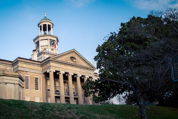 A neoclassical building with a clock tower, columns, and a dome.