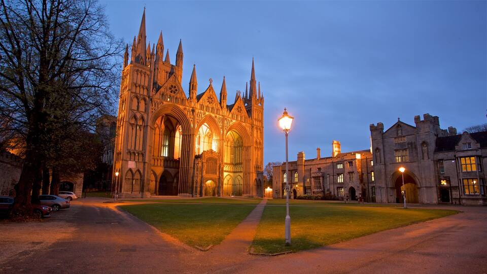 A Gothic cathedral with pointed arches and intricate stonework, surrounded by a well-maintained lawn and historic buildings.