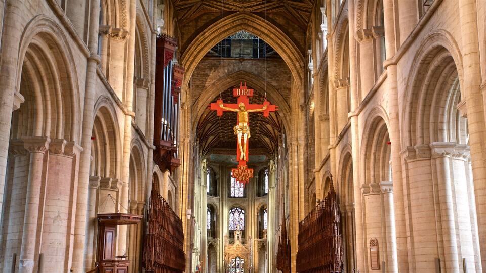 A cathedral interior with a large crucifix, arched ceilings, and stained glass windows.