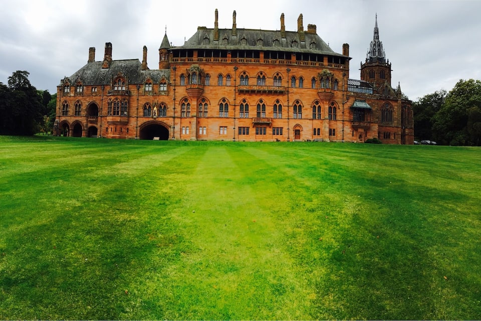 A large, historic building with a prominent tower and arched windows.