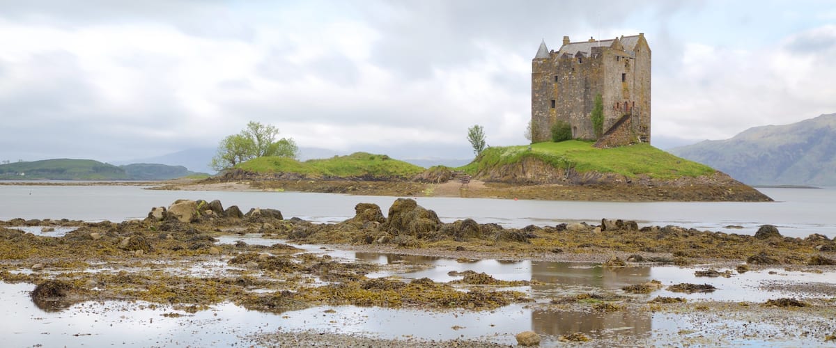 Castle Stalker ofreciendo patrimonio de arquitectura, castillo o palacio y un lago o abrevadero