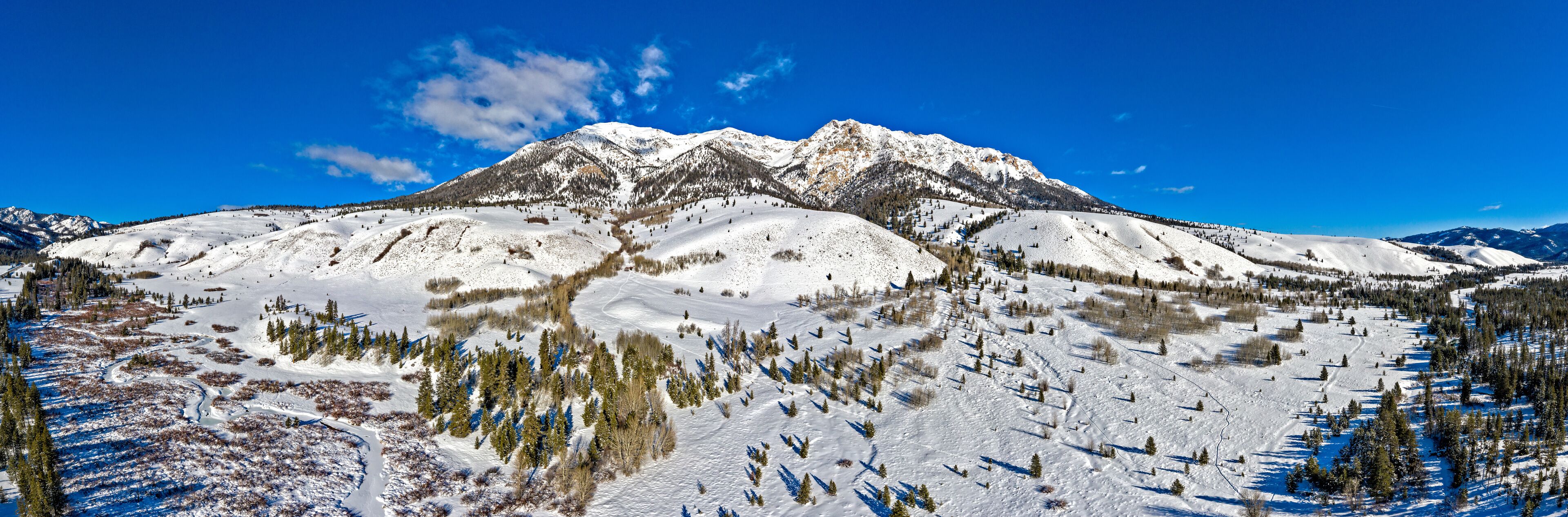 A snow-covered mountain range with a clear blue sky.