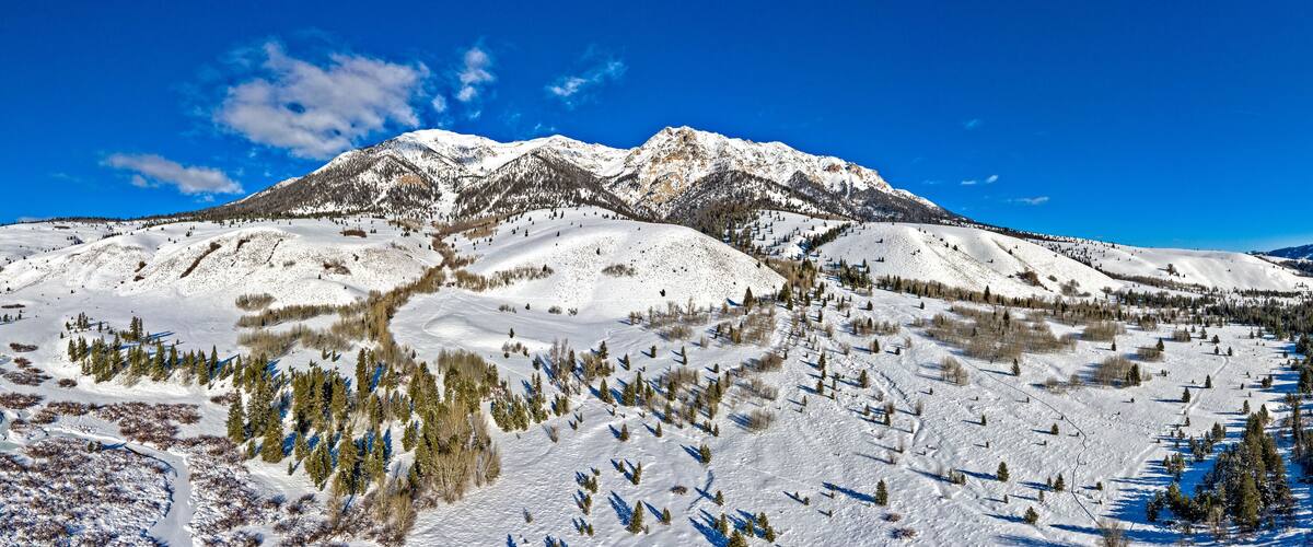 A snow-covered mountain range with a clear blue sky.