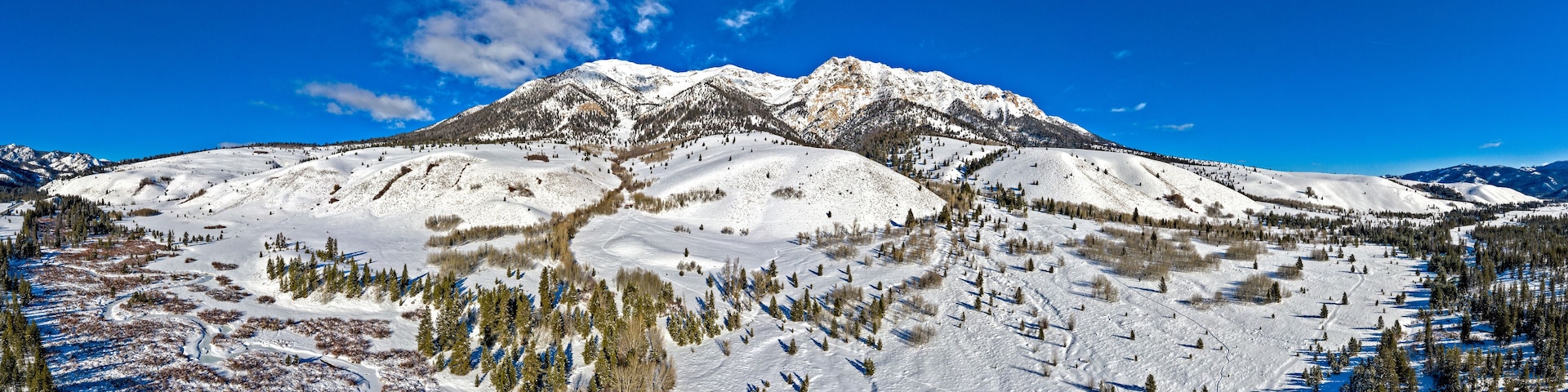 A snow-covered mountain range with a clear blue sky.