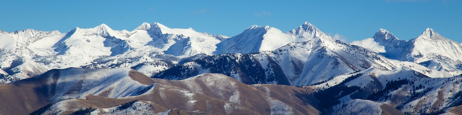 Snow-covered mountain peaks with clear blue skies.