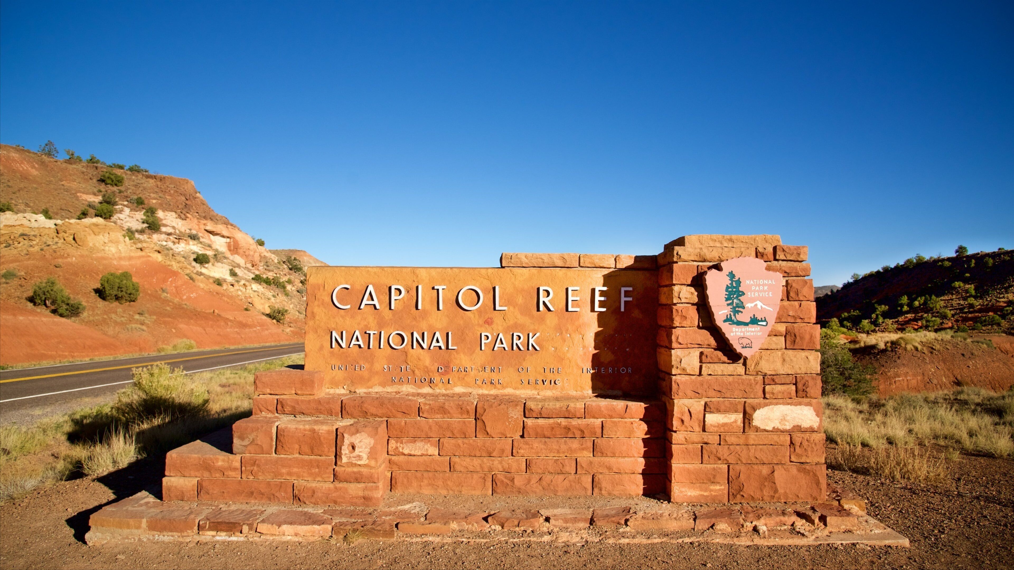 Señal del Parque Nacional Capitol Reef, con un cielo azul despejado al fondo.