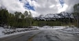 A snow-covered road with mountains in the background.