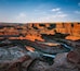 A canyon with layered rock formations and a river.