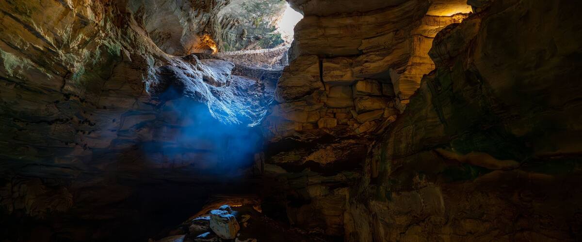 Image depicts a view of Carlsbad Caverns in New Mexico, shrouded in an ethereal mist
