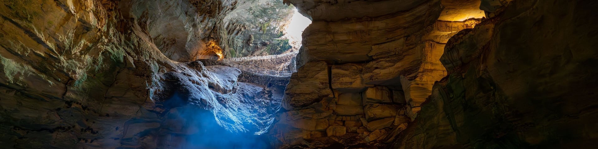 Image depicts a view of Carlsbad Caverns in New Mexico, shrouded in an ethereal mist