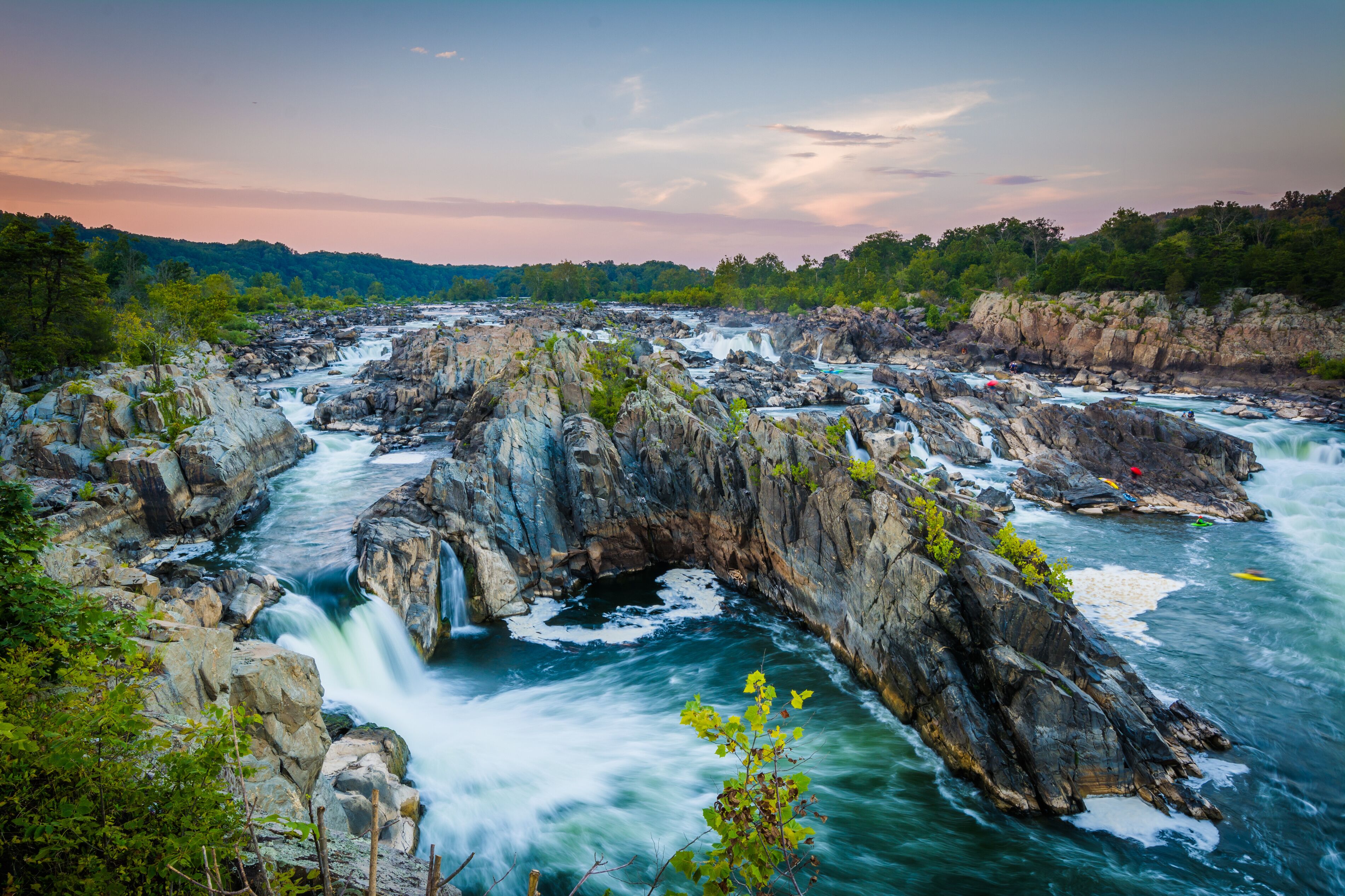 A river flowing through a rocky gorge with waterfalls and lush greenery.