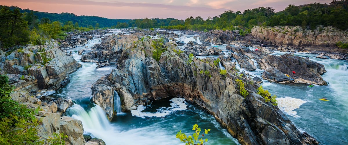 A river flowing through a rocky gorge with waterfalls and lush greenery.