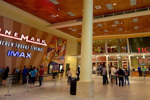 En biografs foyer med et stort IMAX-skilt og en billetluge.