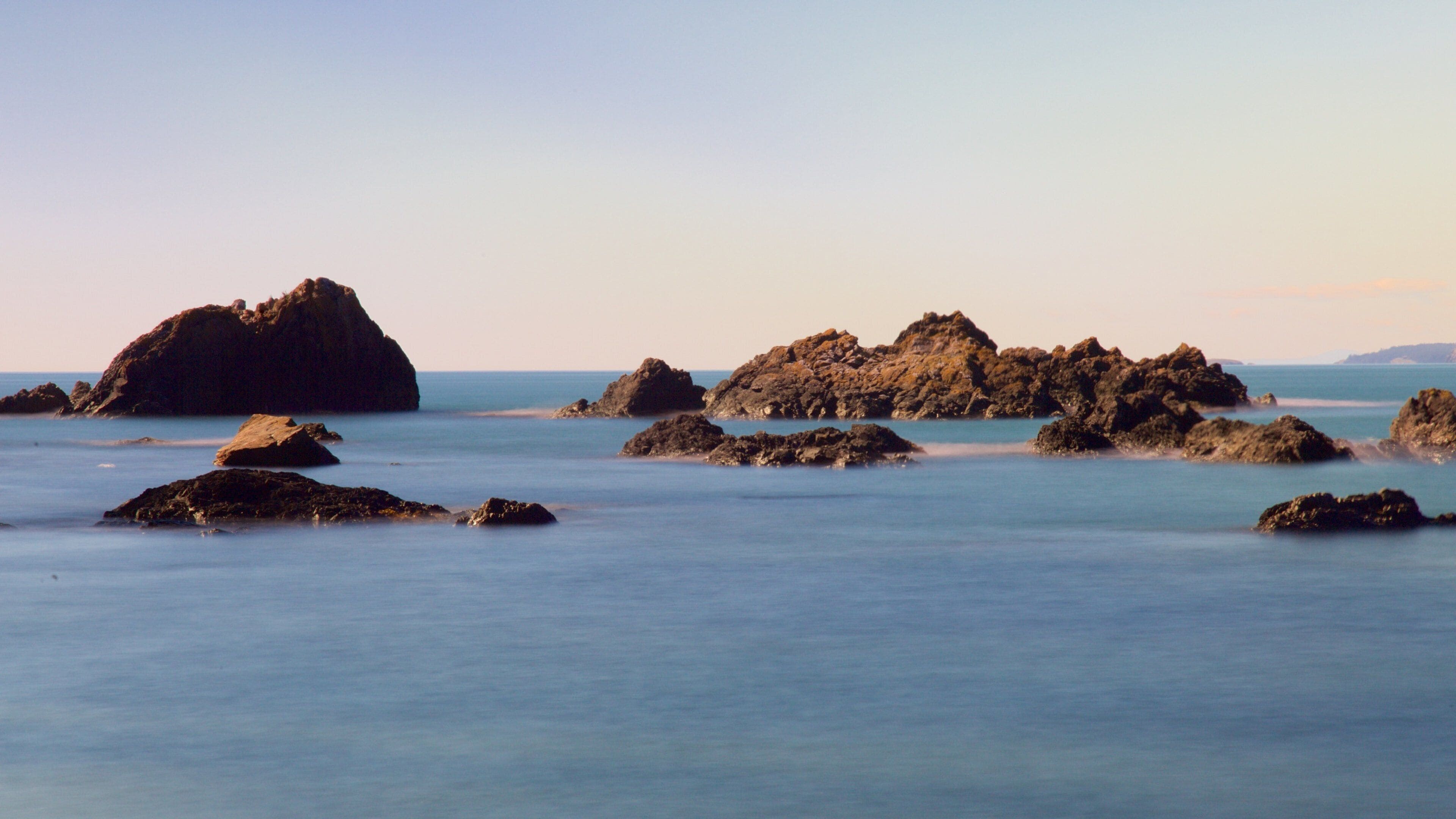 Deception Pass State Park showing a bay or harbor, rocky coastline and a sunset