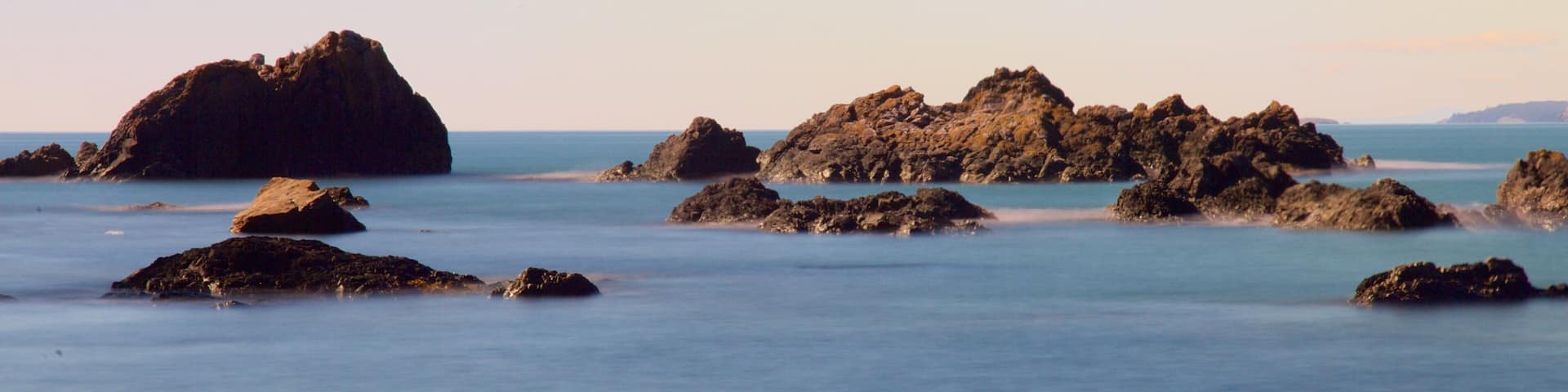 Deception Pass State Park showing a bay or harbor, rocky coastline and a sunset