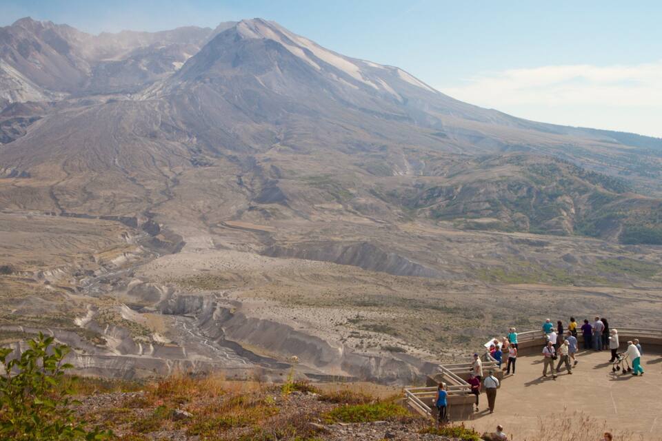 A mountainous landscape with a group of people at a viewing platform.
