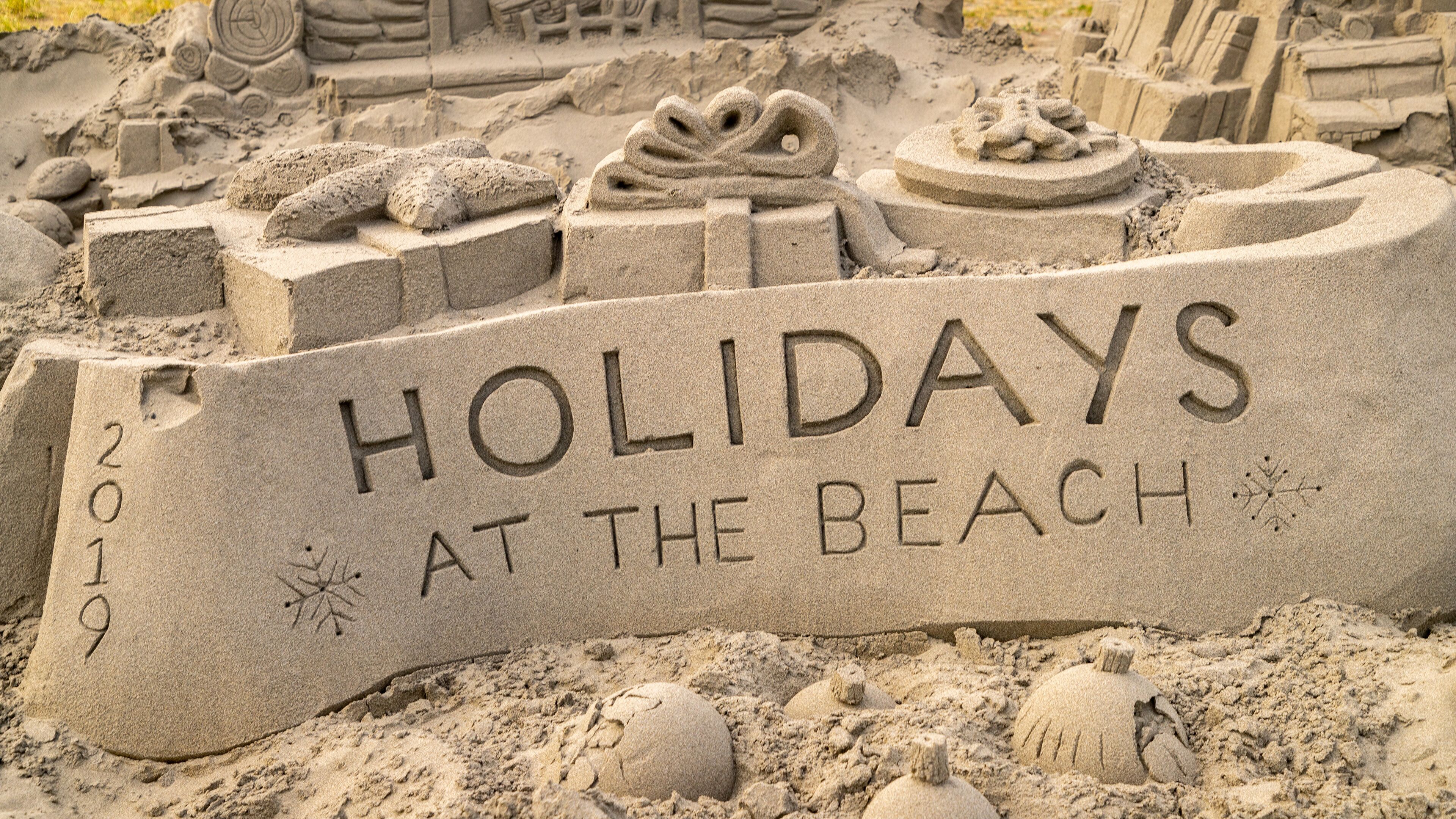 A sand sculpture with the text "HOLIDAYS AT THE BEACH 2019".