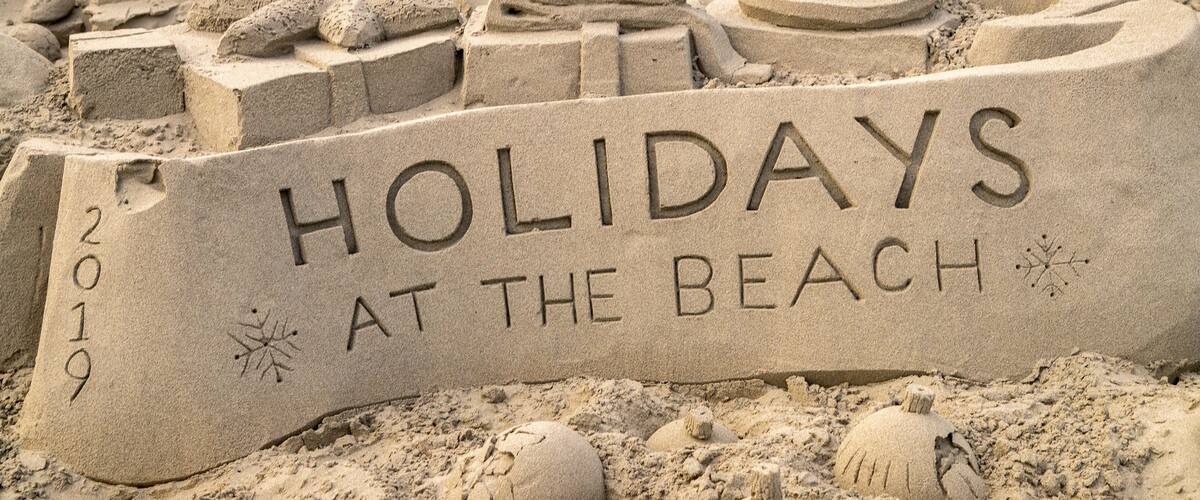 A sand sculpture with the text "HOLIDAYS AT THE BEACH 2019".