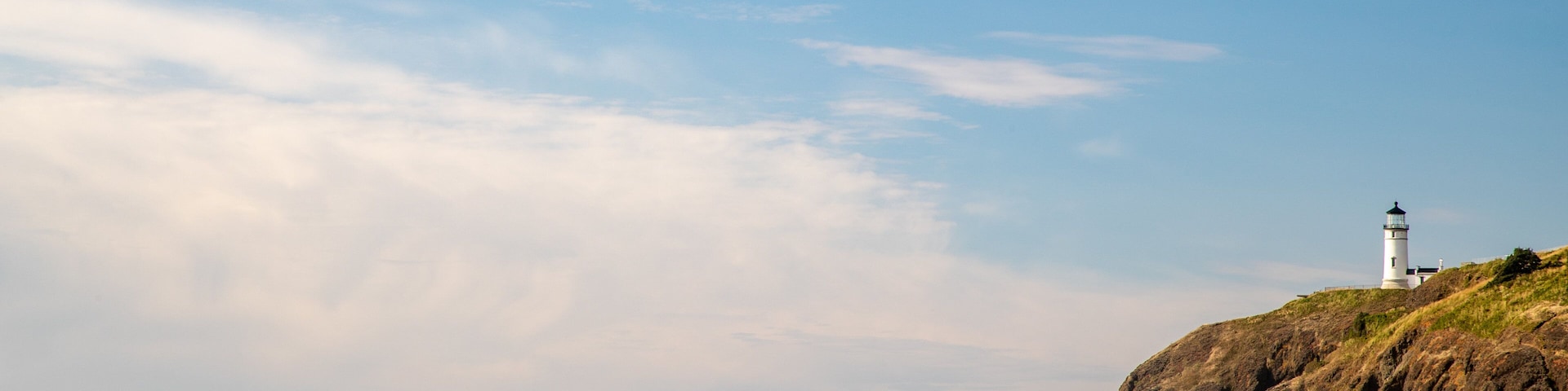 Cape Disappointment State Park which includes a beach, a sunset and a lighthouse