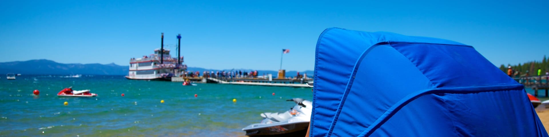 Zephyr Cove Beach showing jet skiing, boating and a beach