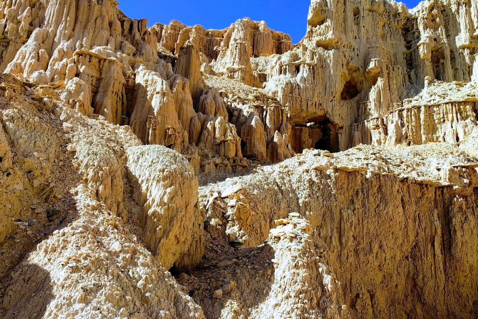 A rugged desert landscape with eroded rock formations and sparse vegetation.