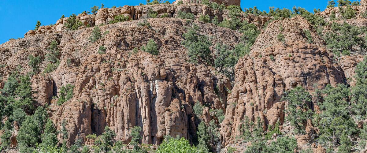 A rugged mountain with a prominent rocky peak and sparse vegetation.