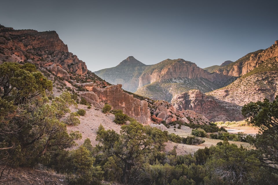 A rugged canyon landscape with steep cliffs and sparse vegetation.