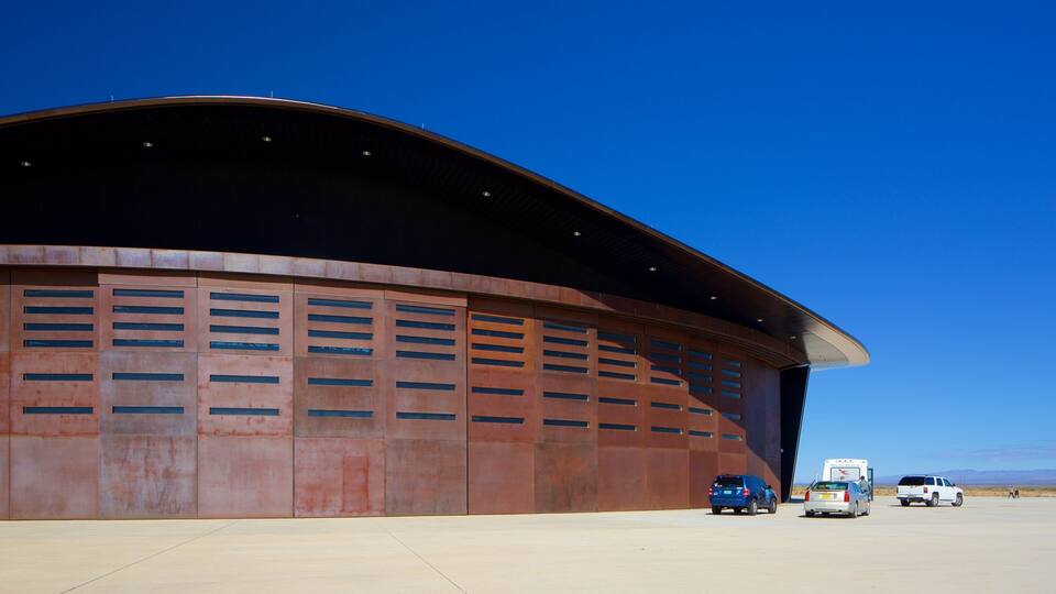 A large, curved building with a metallic exterior and multiple garage doors.