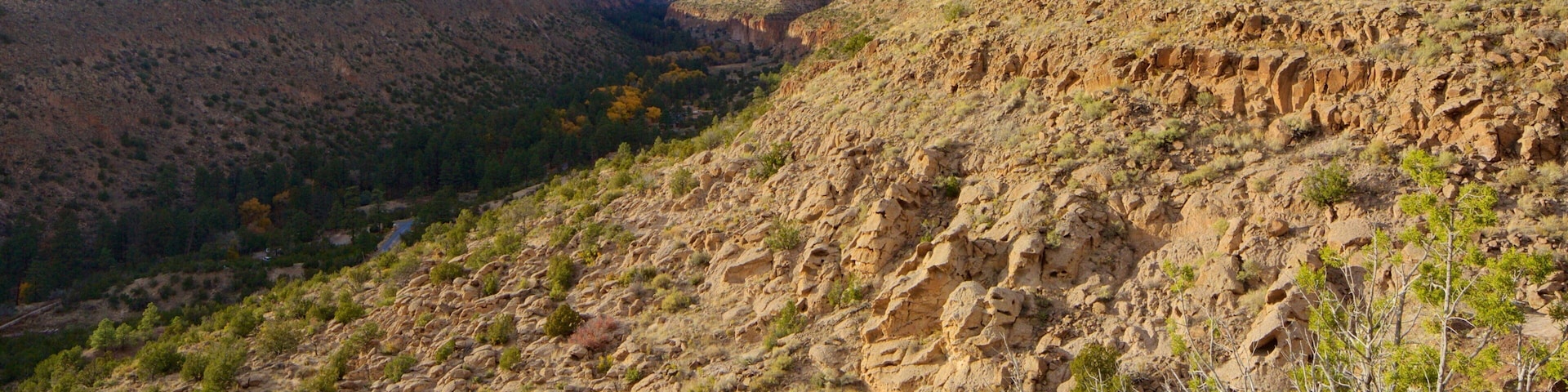 A rugged mountain landscape with sparse vegetation and a clear sky.