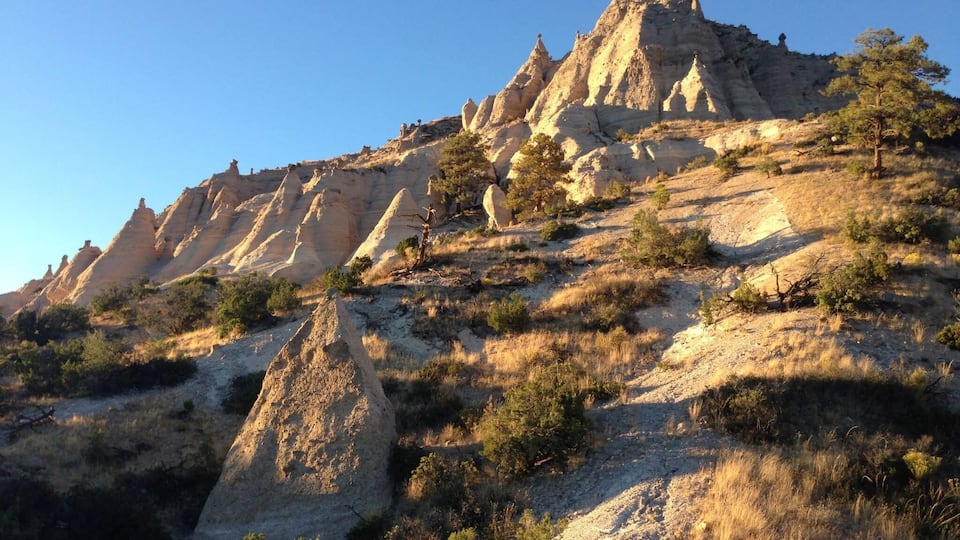 A rugged mountain landscape with prominent rock formations and sparse vegetation.