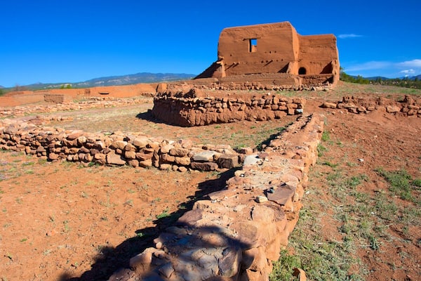 Ancient ruins with stone walls and a large building with a window.