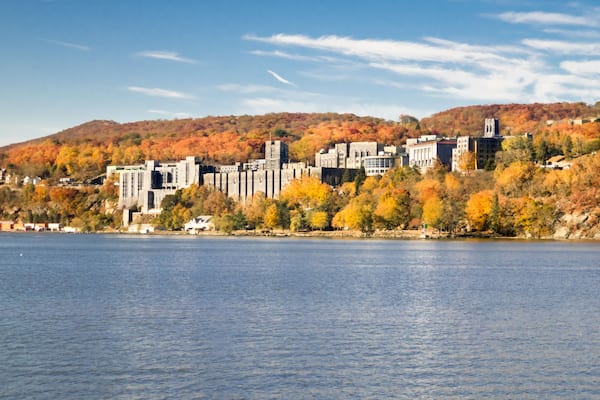 The United States Military Academy at West Point at sunrise surrounded by brilliant autumn colors. View from the Hudson River.