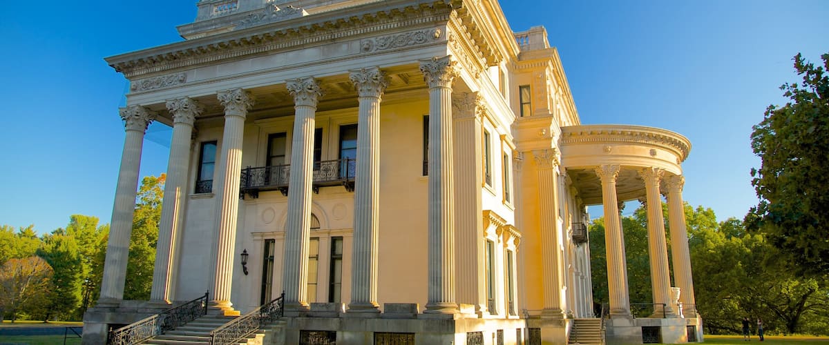 A neoclassical building with columns, a balcony, and a circular pavilion.