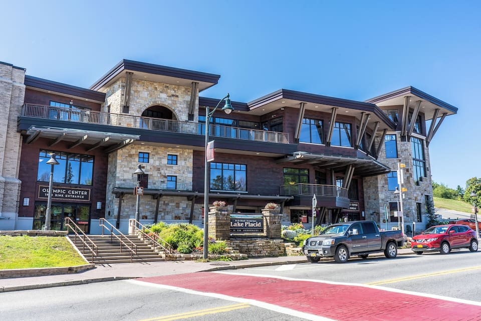 A multi-story building with a stone facade, a sign reading "Olympic Center," and a red bike lane.