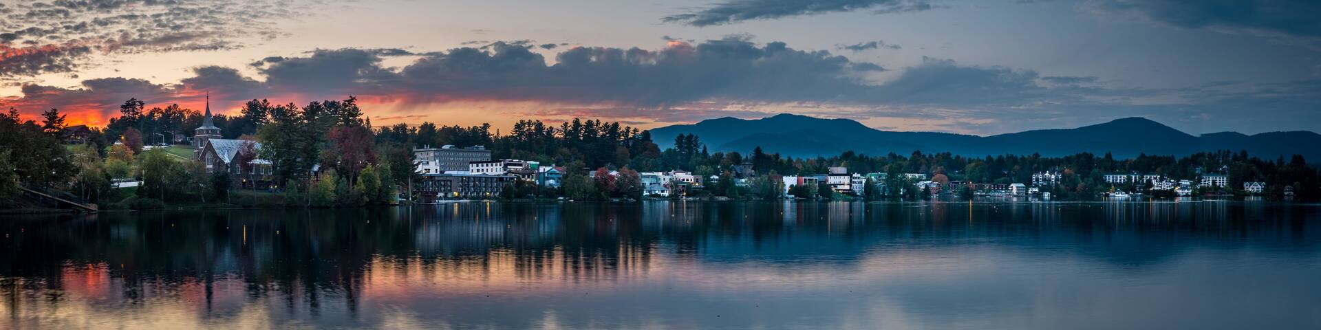 A panoramic view of the village of Lake Placid as seen from across Mirror Lake at sunset