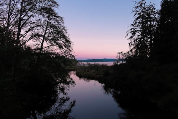 As promised, another sunset to finish off the day.
The trail that begins at Ozette Lake is billed as a 10.5 mile triangle which leads you down to the ocean and across a couple of miles of beach.
But, practically speaking, you need to find a way to navigate the surf unless you hit the beach at very low tide. Our hike stretched out for about 12 miles, as we made serpentine patterns through the exposed rocks out and back to see all the sea stacks.
When we returned to the lake, the sun had all but rolled over the lip of the earth. But it left a few colors dangling in the air, and Ozette Lake caught them all and tossed them back up like a smooth and silky sheet of glass.
