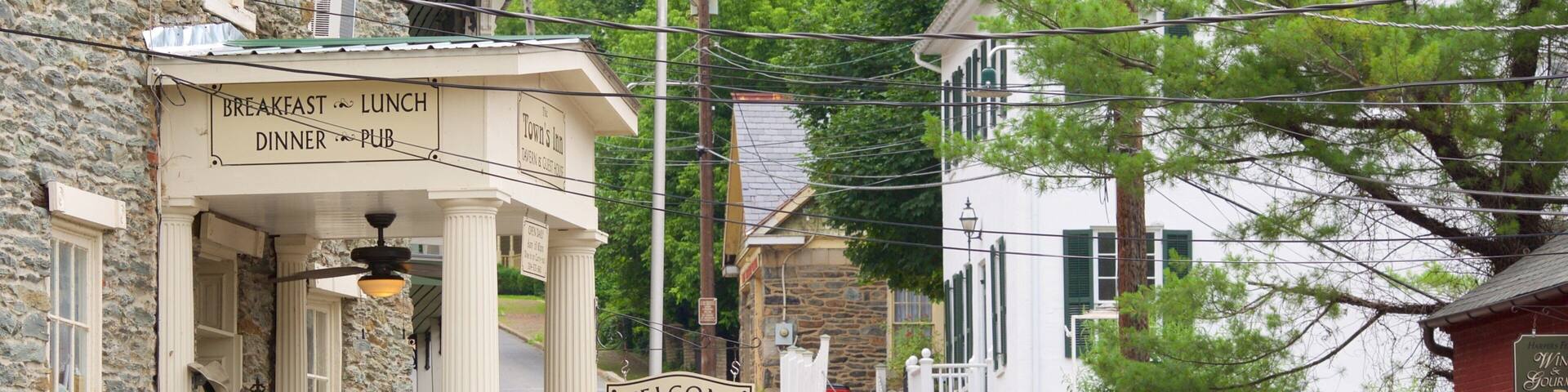 A town's inn with a signboard advertising breakfast, lunch, dinner, and pub services.