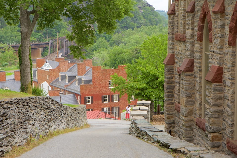 A stone pathway leading to a red brick building with a stone wall on one side.
