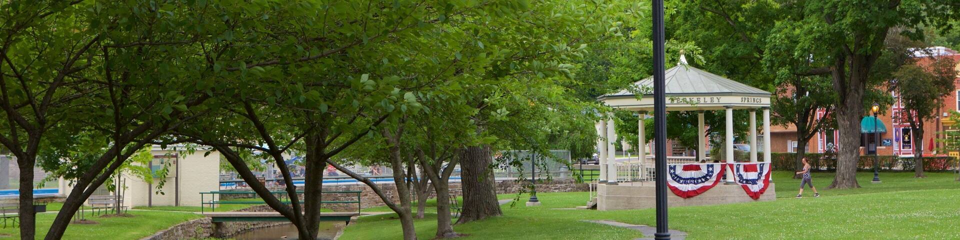 Un parc doté d’un kiosque, d’arbres verdoyants, d’un chemin pavé et de panneaux interdisant la consommation de bière et de boissons alcoolisées.