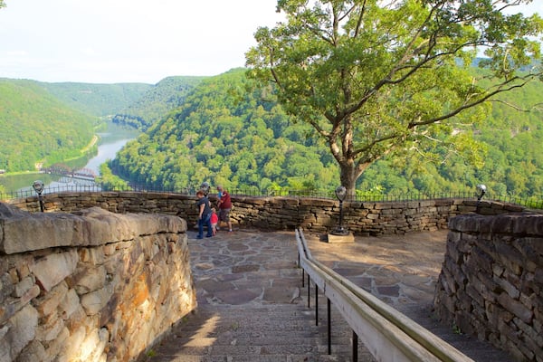 A stone staircase leading to a viewpoint overlooking a river and forested hills.
