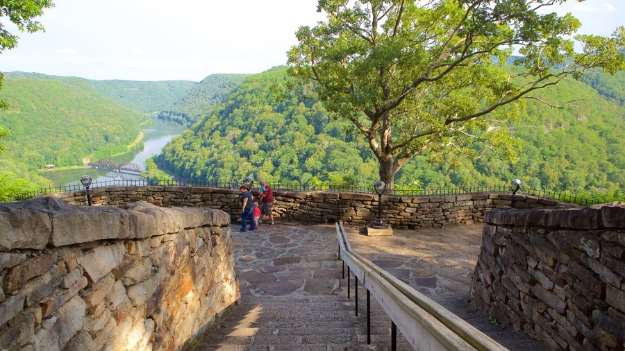 Un escalier en pierre mène à un point de vue d’où l’on peut admirer une rivière et des collines boisées.